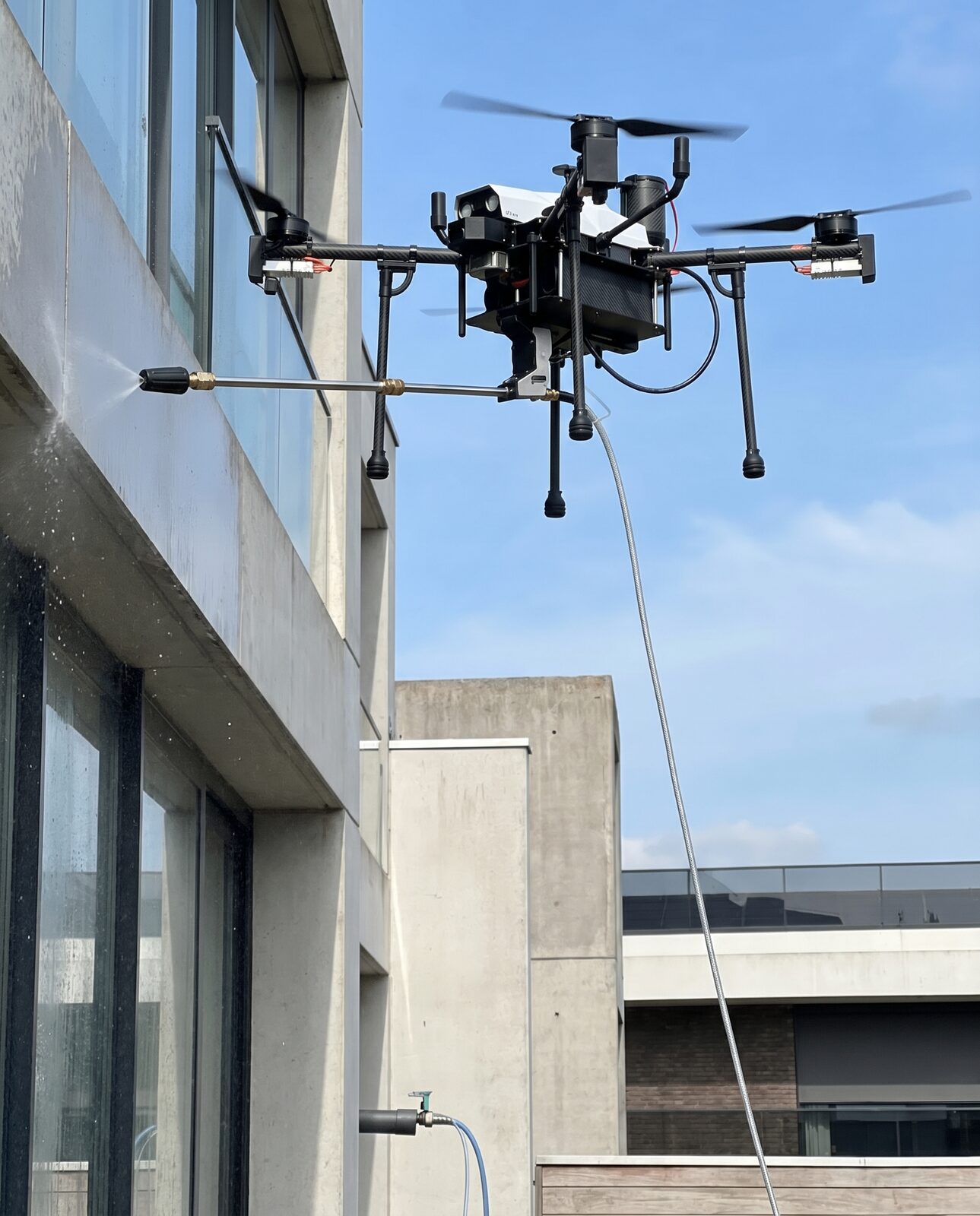 Tethered SKAI drone with pressure lance beside a building